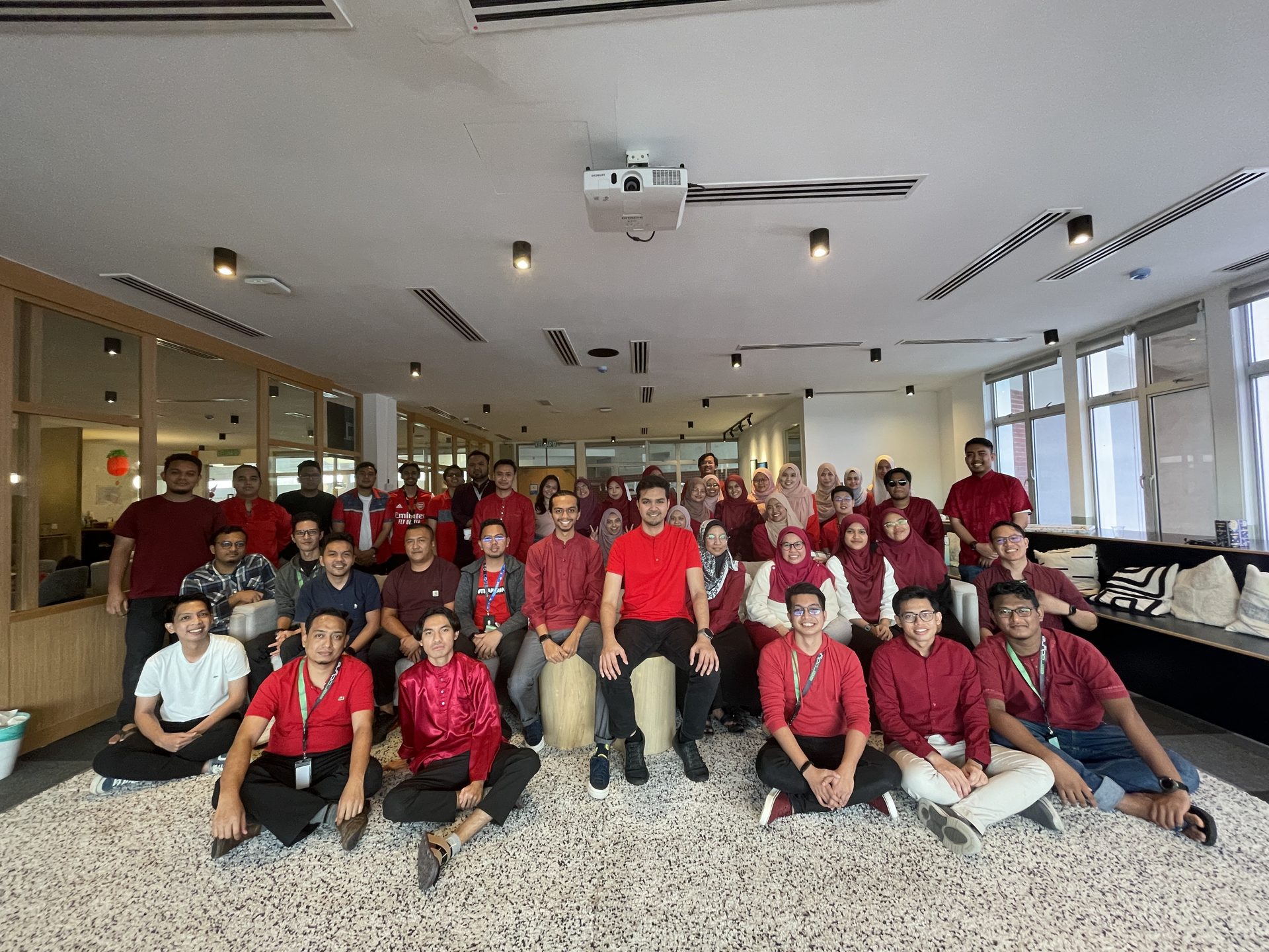 Alif seated among a team of about fifty engineers and designers in an office