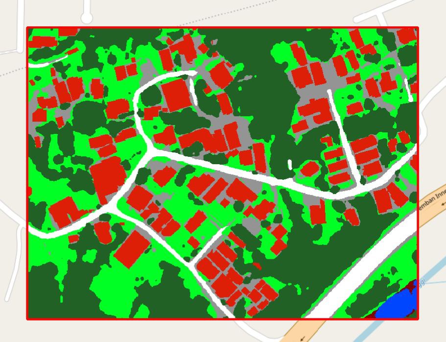 The same area classified: buildings in red, roads in white, trees and grass in two greens